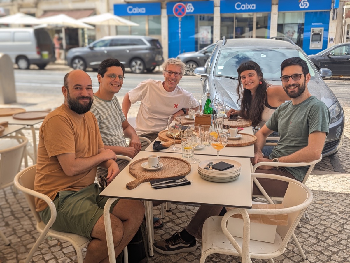 The Development Seed team sitting together at an outdoor table in Lisbon